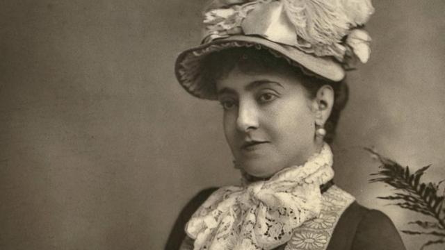 Eine Fotografie der italienischen Operndiva Adelina Patti, auf der sie einen Hut trägt. Die Aufnahme ist aus dem Jahr 1882. Sie ist zu dem Zeitpunkt ungefähr 39 Jahre alt.