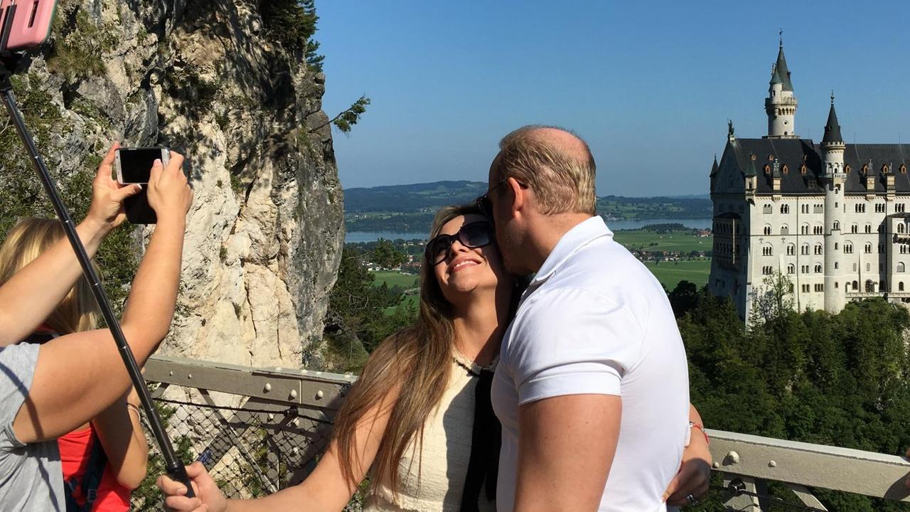 Ein Paar macht ein Selfie von sich. Im Hintergrund das Schloss Neuschwanstein. Ein Paar macht ein Selfie von sich. Im Hintergrund das Schloss Neuschwanstein.