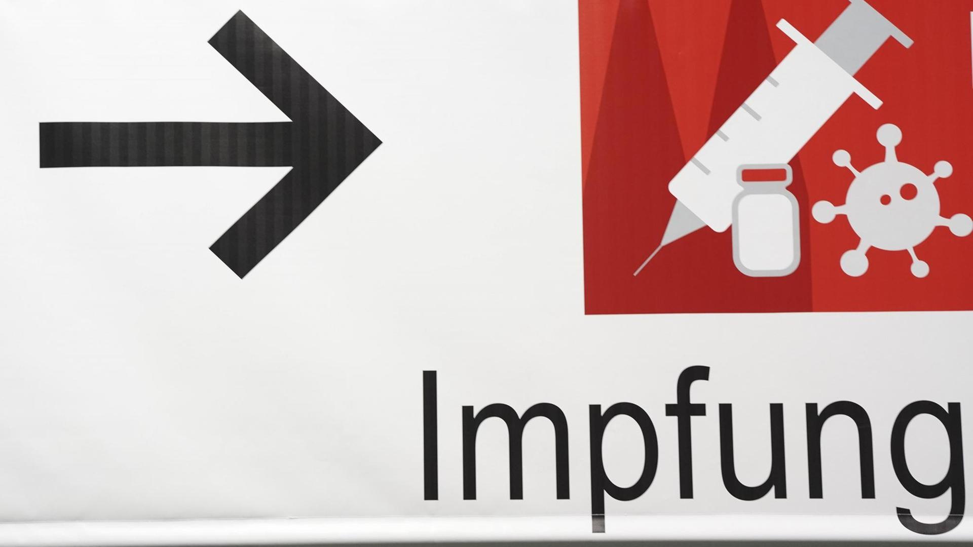 Ein Schild weist den Weg im Impfzentrum in der Messe Köln Ein Schild weist den Weg im Impfzentrum in der Messe Köln