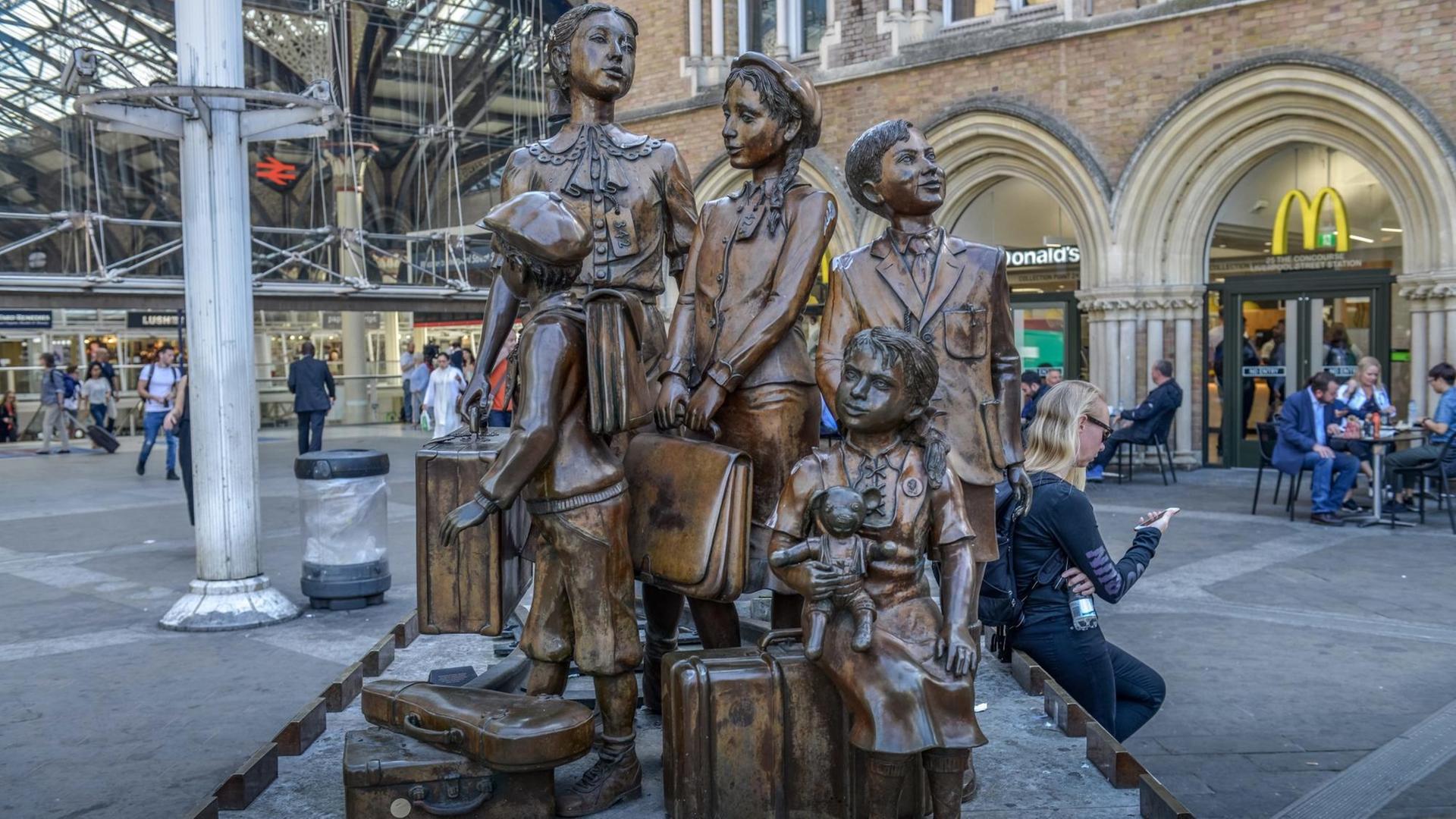 Das Foto zeigt das Denkmal "Kindertransport – Die Ankunft", Vorplatz der Liverpool Street Station, London. Das Denkmal stellt ankommende geflüchtete jüdische Kinder mit ihrem Gepäck dar. Das Foto zeigt das Denkmal "Kindertransport – Die Ankunft", Vorplatz der Liverpool Street Station, London. Das Denkmal stellt ankommende geflüchtete jüdische Kinder mit ihrem Gepäck dar.