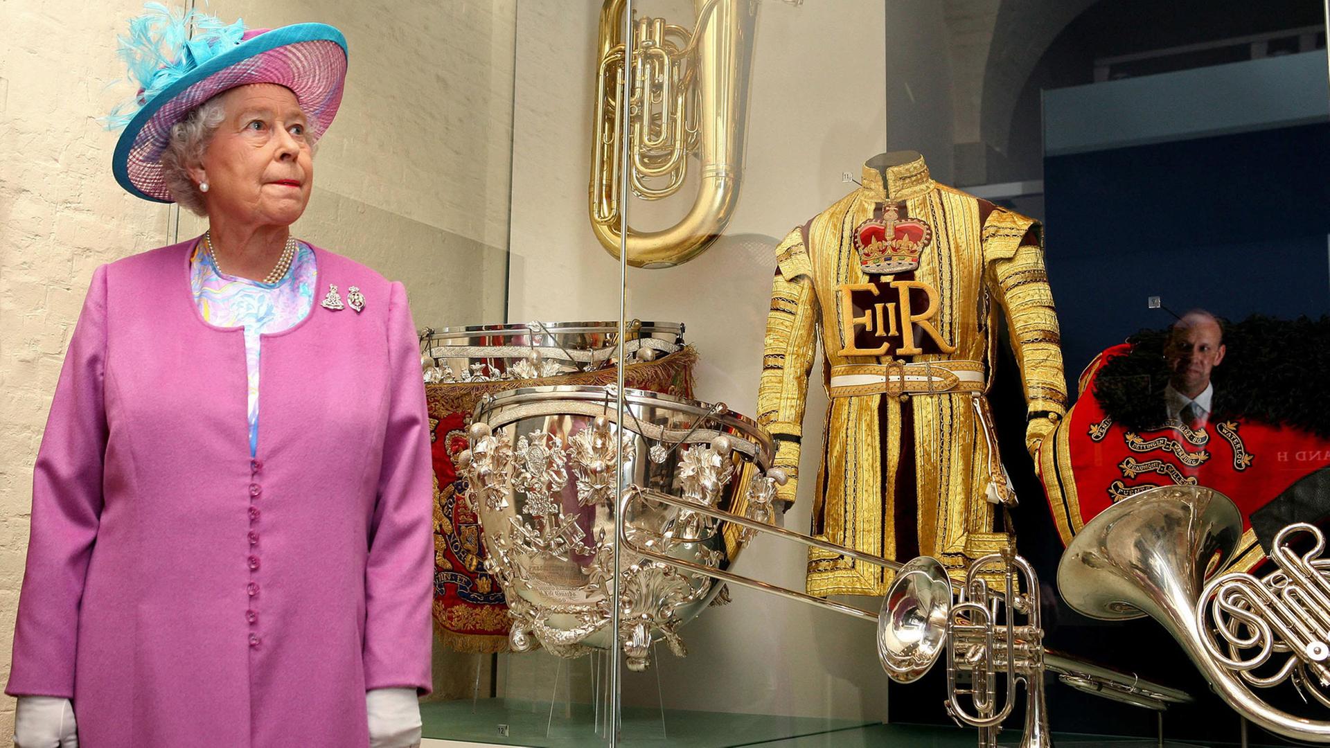 Die britische Königin Elisabeth II. vor einer Vitrine mit Musikinstrumenten, auf genommen am 13.6.2007 im Household Cavalry Museum in London. Die britische Königin Elisabeth II. vor einer Vitrine mit Musikinstrumenten, auf genommen am 13.6.2007 im Household Cavalry Museum in London.