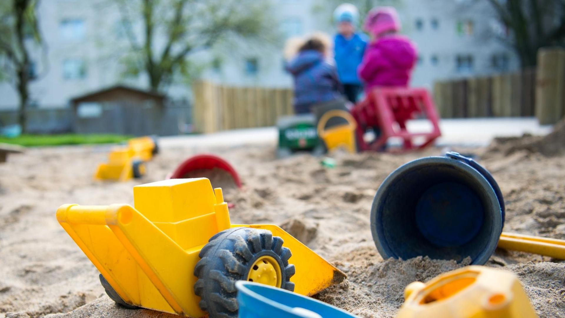 Spielzeug liegt am 18.04.2016 in einem Sandkasten in einer Kindertagesstätte