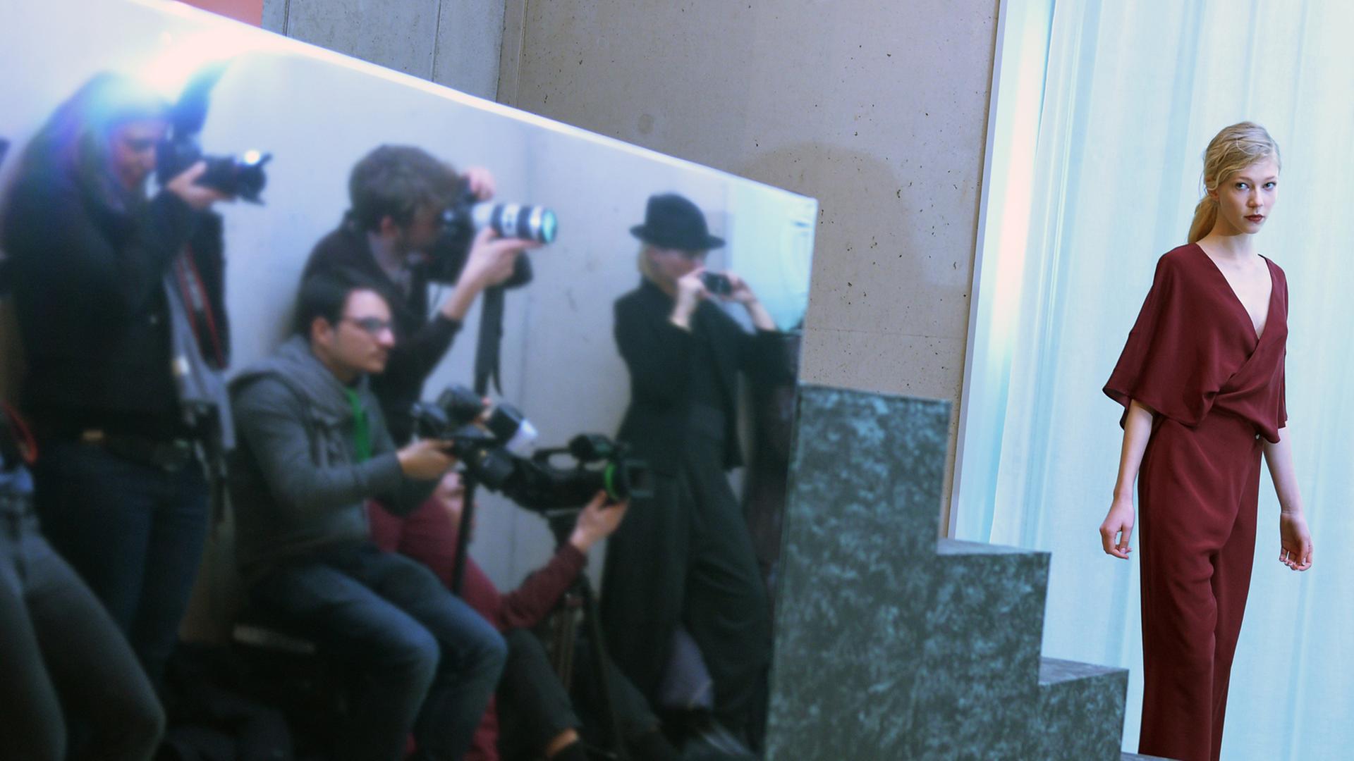 Ein Model präsentiert Mode vor mehreren Fotografen. Ein Model präsentiert Mode vor mehreren Fotografen.