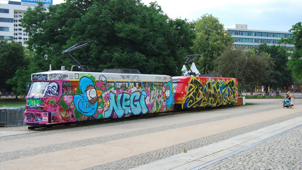 Eine kunterbunt bemalte und besprühte alte Straßenbahn im Chemnitzer Zentrum.