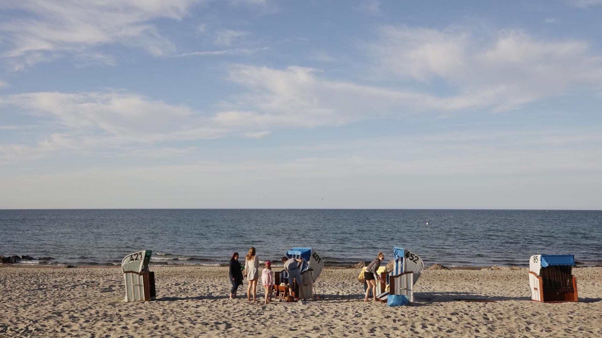 Blick auf den Strand mit Strandkörben und ein paar wenigen Menschen. Im Hintergrund die Ostsee. Blick auf den Strand mit Strandkörben und ein paar wenigen Menschen. Im Hintergrund die Ostsee.