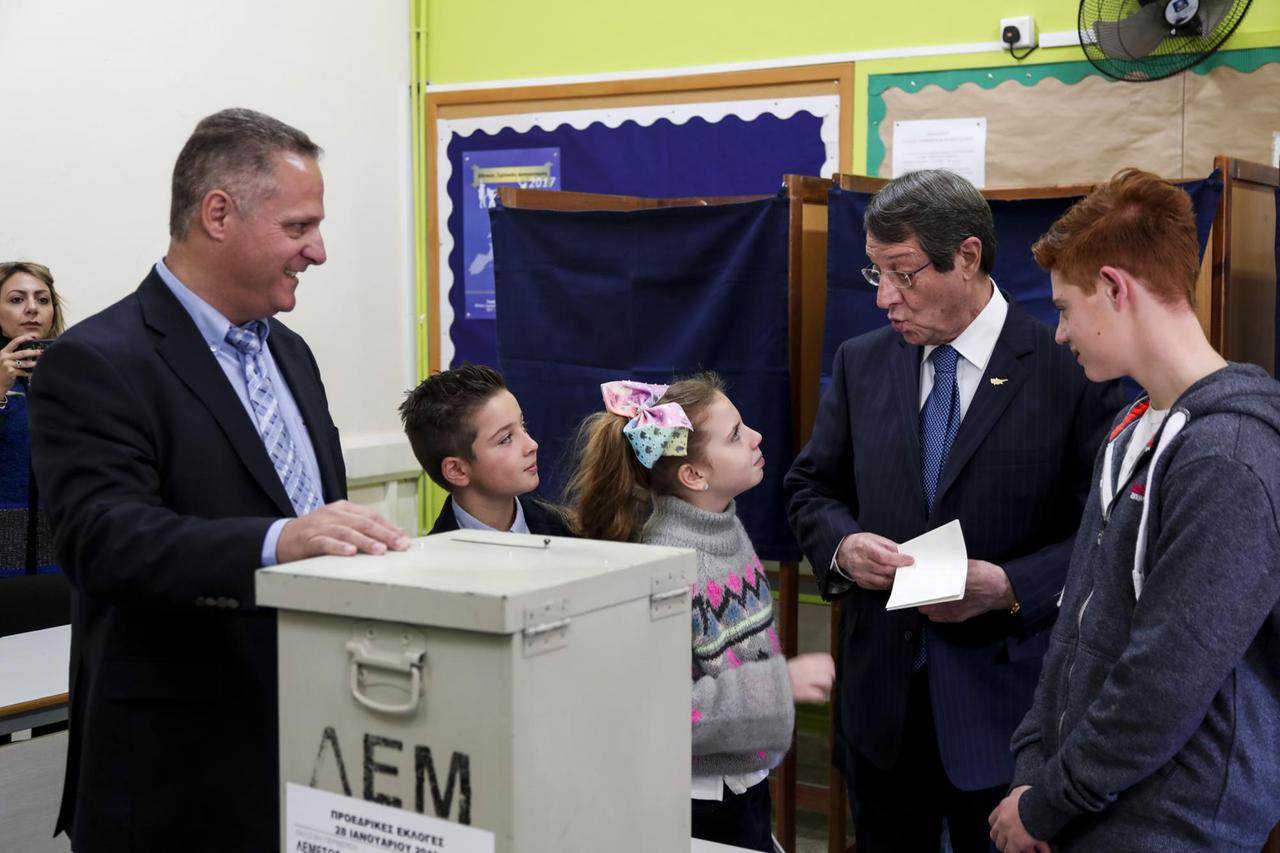 Anastasiades steht an der Wahlurne, umringt von seiner Familie.