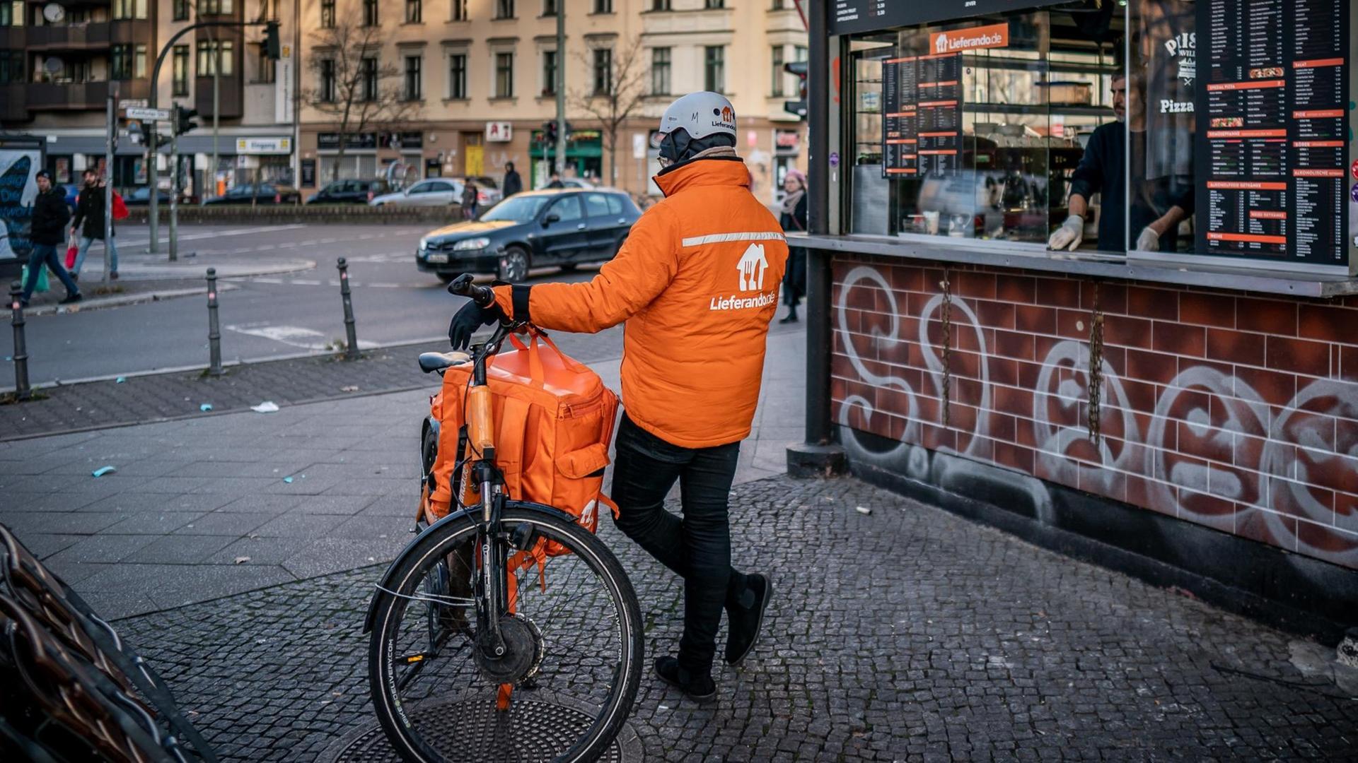 Ein Fahrrad Kurier des Online Essens Lieferservice "Lieferando" wartet an einem Kiosk in Kreuzberg auf neue Aufträge. Ein Fahrrad Kurier des Online Essens Lieferservice "Lieferando" wartet an einem Kiosk in Kreuzberg auf neue Aufträge.