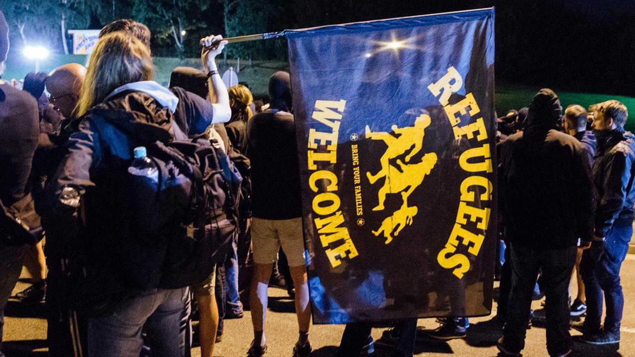 Linke Demonstranten stehen vor dem ehemaligen Baumarkt in Heidenau auf der Straße. Linke Demonstranten stehen vor dem ehemaligen Baumarkt in Heidenau auf der Straße.