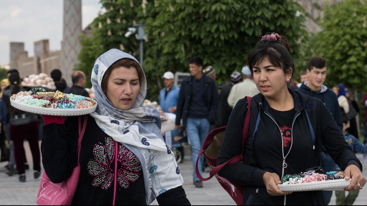 Zwei Frauen mit Verkaufspaletten auf den Schultern Zwei Frauen mit Verkaufspaletten auf den Schultern