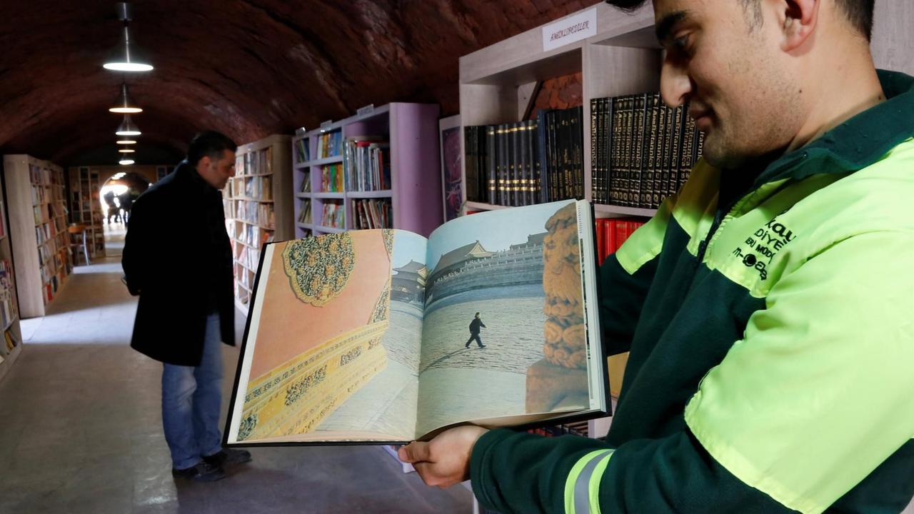 Ein Mitarbeiter zeigt ein Buch über vdie Verbotene Stadt in der Bücherei der Müllmänner von Ankara, die in einer ehemaligen Ziegelsteinfabrik im Stadtteil Cankaya eingerichtet wurde