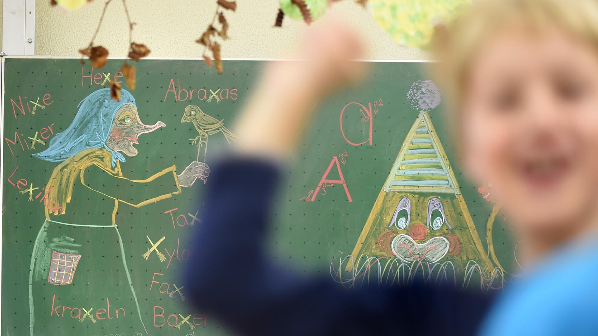 Ein Junge wirft in einem Klassenzimmer mit einem Gegenstand. Im Hintergrund ist ein Tafelbild mit einer Hexe. Ein Junge wirft in einem Klassenzimmer mit einem Gegenstand. Im Hintergrund ist ein Tafelbild mit einer Hexe.
