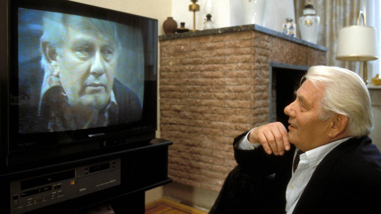Schauspieler Peter Borgelt betrachtet sich im Fernsehen.