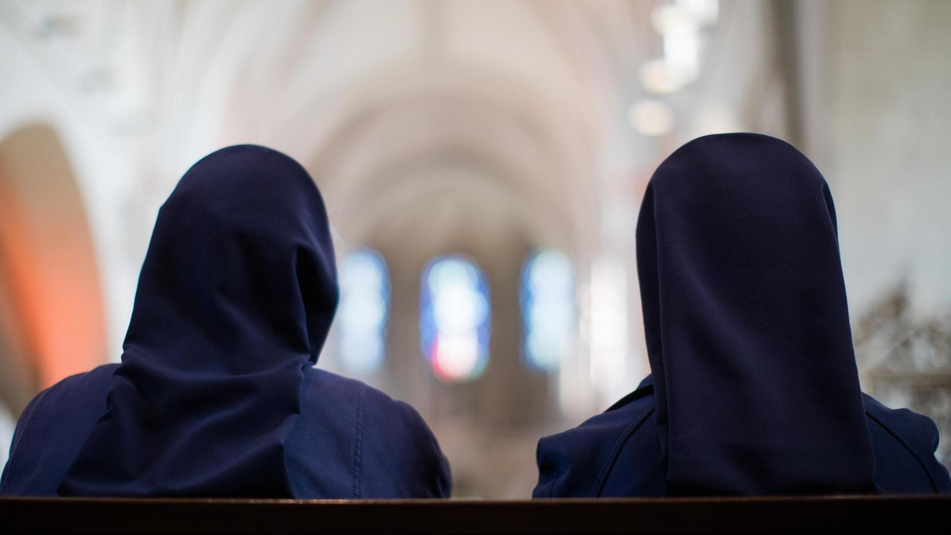 Zwei Ordensschwestern sitzen im Dom. Zwei Ordensschwestern sitzen im Dom.