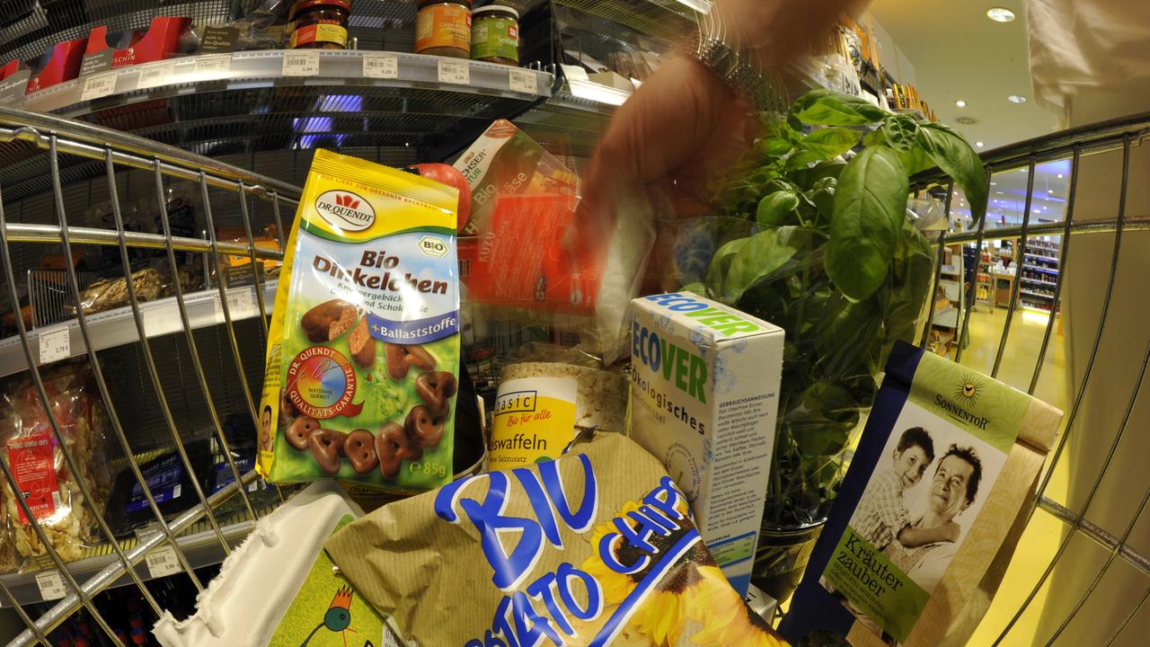 Ein Einkaufswagen ist gefüllt mit verschiedenen Bio-Produkten.