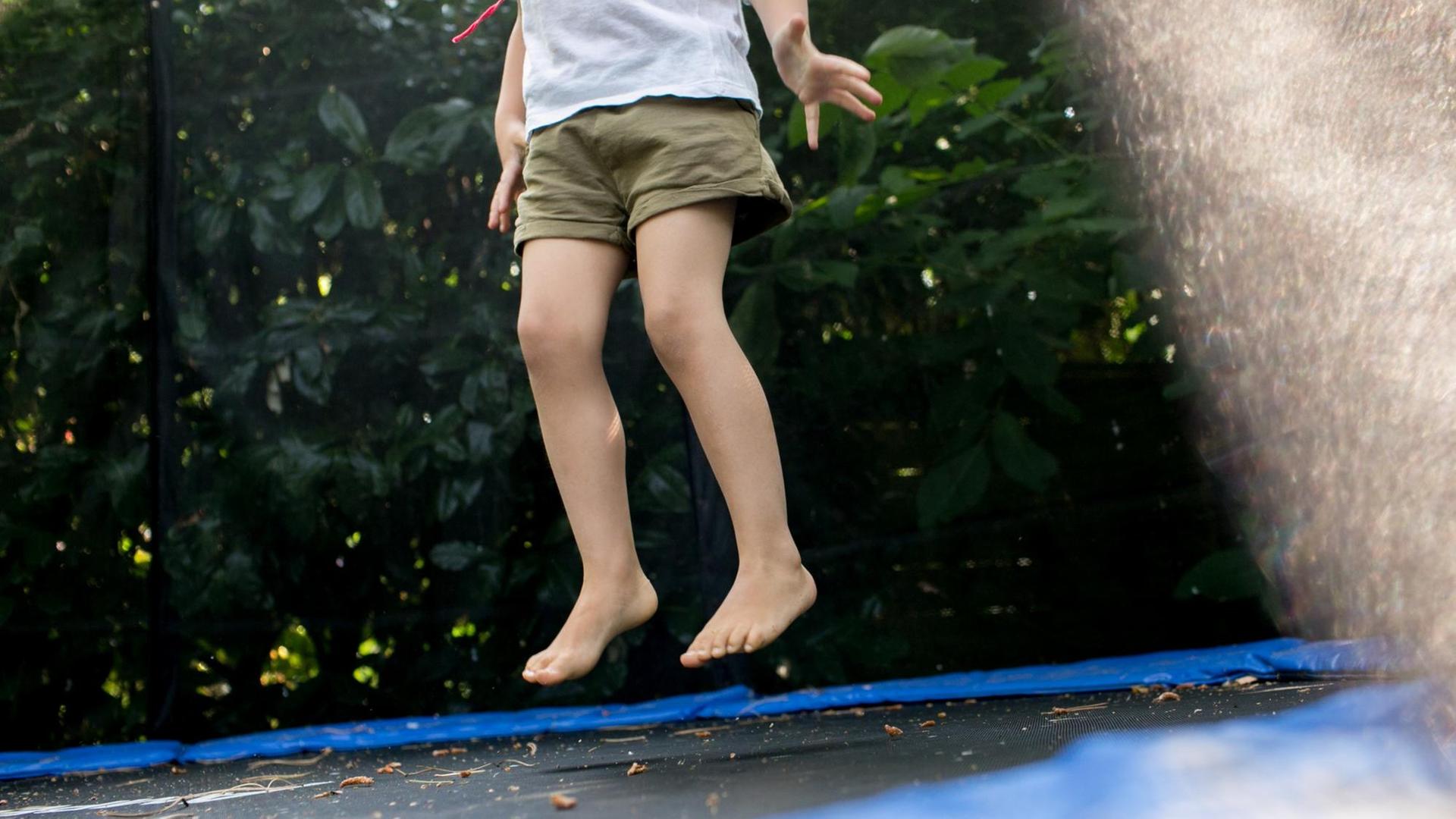 Ein Mädchen springt am 14.07.2018 in einem Garten in Düsseldorf (Nordrhein-Westfalen) auf einem Trampolin. Ein Mädchen springt am 14.07.2018 in einem Garten in Düsseldorf (Nordrhein-Westfalen) auf einem Trampolin.