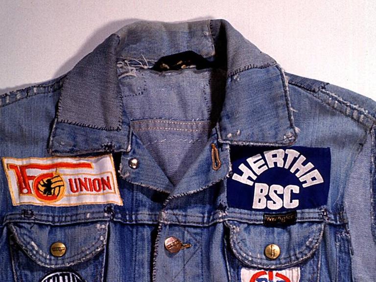 Eine Fanjacke aus Jeansstoff mit Emblemen beider Berliner Vereine.