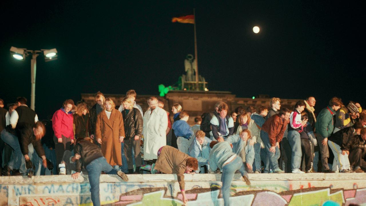 In der Nacht vom 9. auf den 10. November 1989 klettern Menschen auf das Brandenburger Tor.