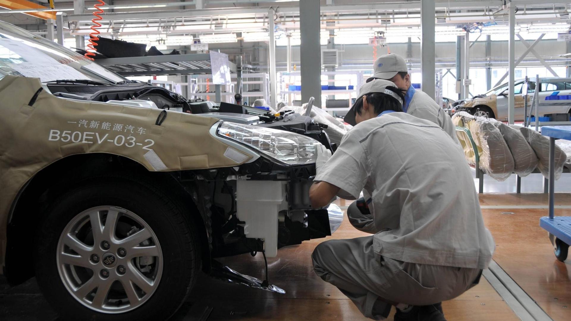Arbeiter in einer Fertigunsstraße im VW-FAW-Werk in Changchun im Norden Chinas. Arbeiter in einer Fertigunsstraße im VW-FAW-Werk in Changchun im Norden Chinas.