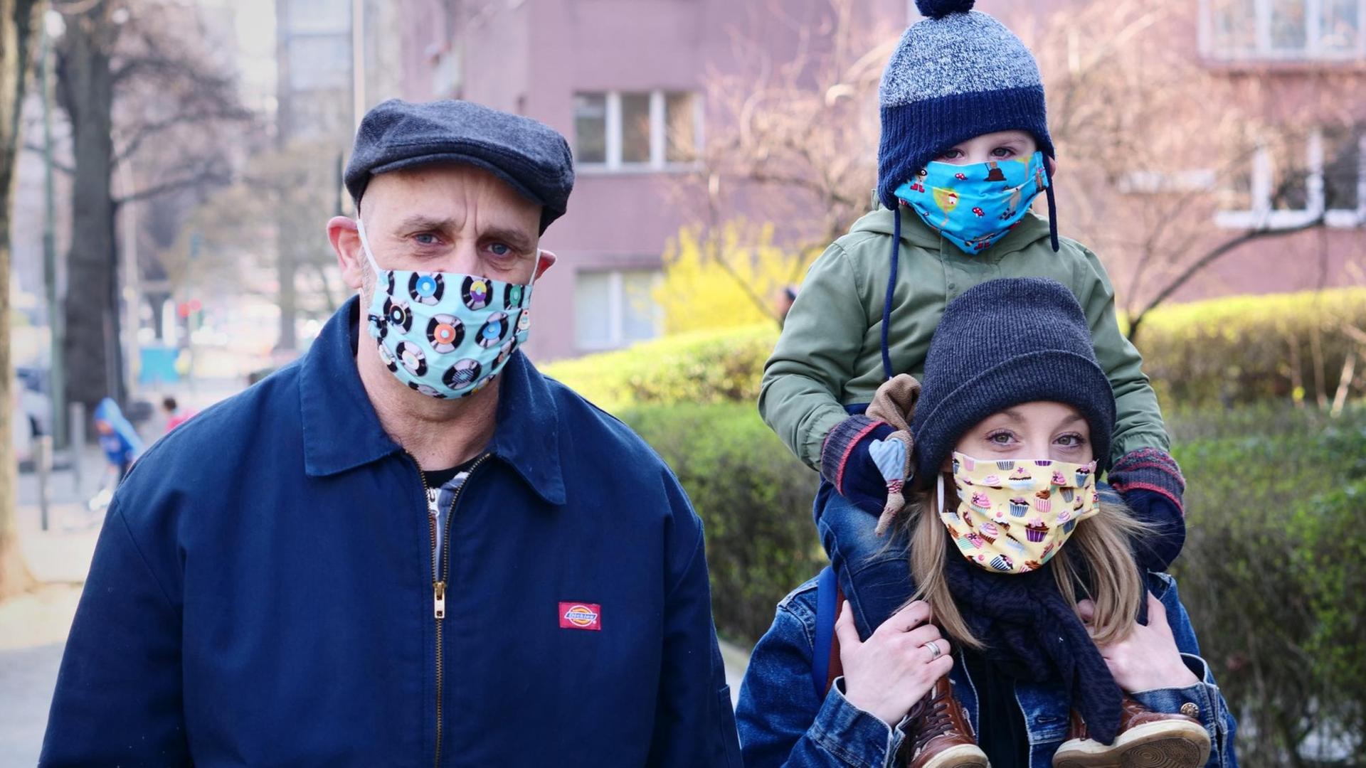 Eine Familie mit Vater, Mutter und kleinem Kind trägt Mund-Schutz. Eine Familie mit Vater, Mutter und kleinem Kind trägt Mund-Schutz.