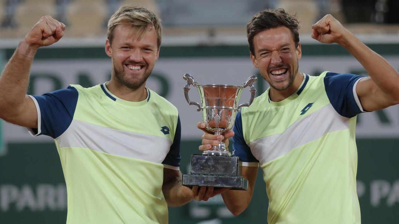 Kevin Krawietz (l) und Andreas Mies aus Deutschland feiern mit der Trophäe den Finalsieg im Doppel der French Open. Kevin Krawietz (l) und Andreas Mies aus Deutschland feiern mit der Trophäe den Finalsieg im Doppel der French Open.