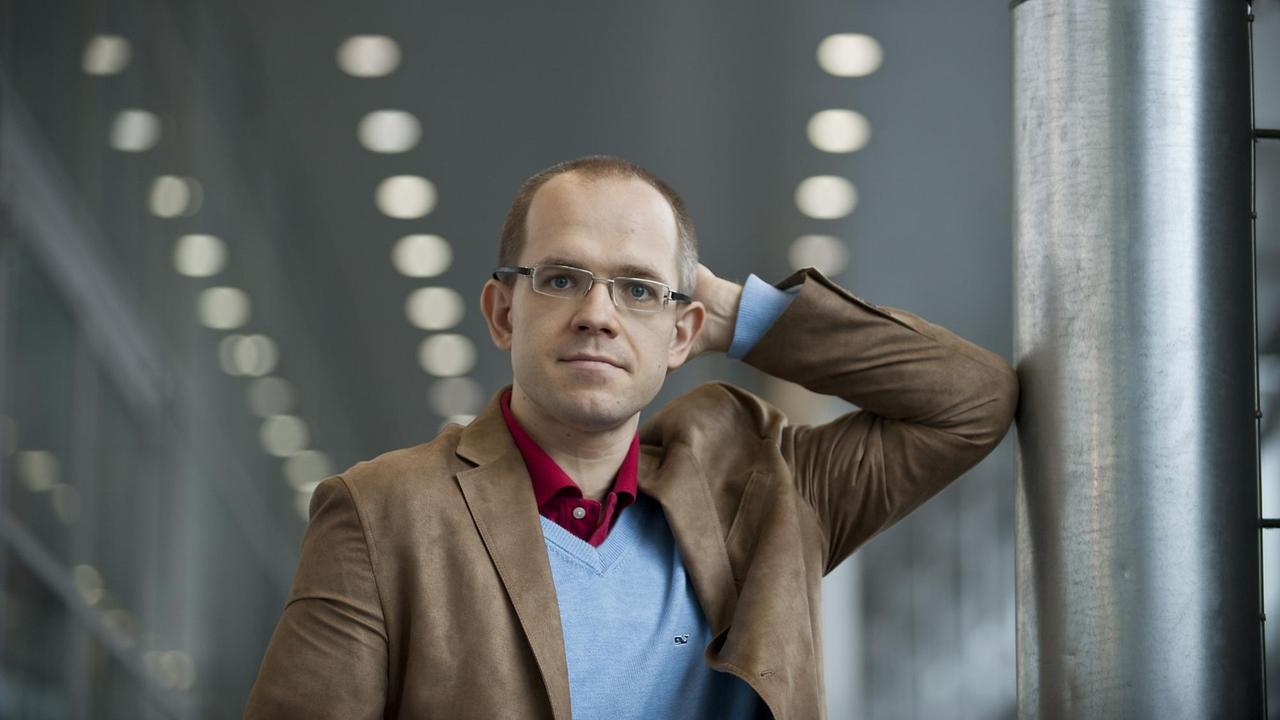 Evgeny Morozov steht mit dem Ellenbogen an eine Säule gelehnt und schaut in die Kamera. Evgeny Morozov steht mit dem Ellenbogen an eine Säule gelehnt und schaut in die Kamera.