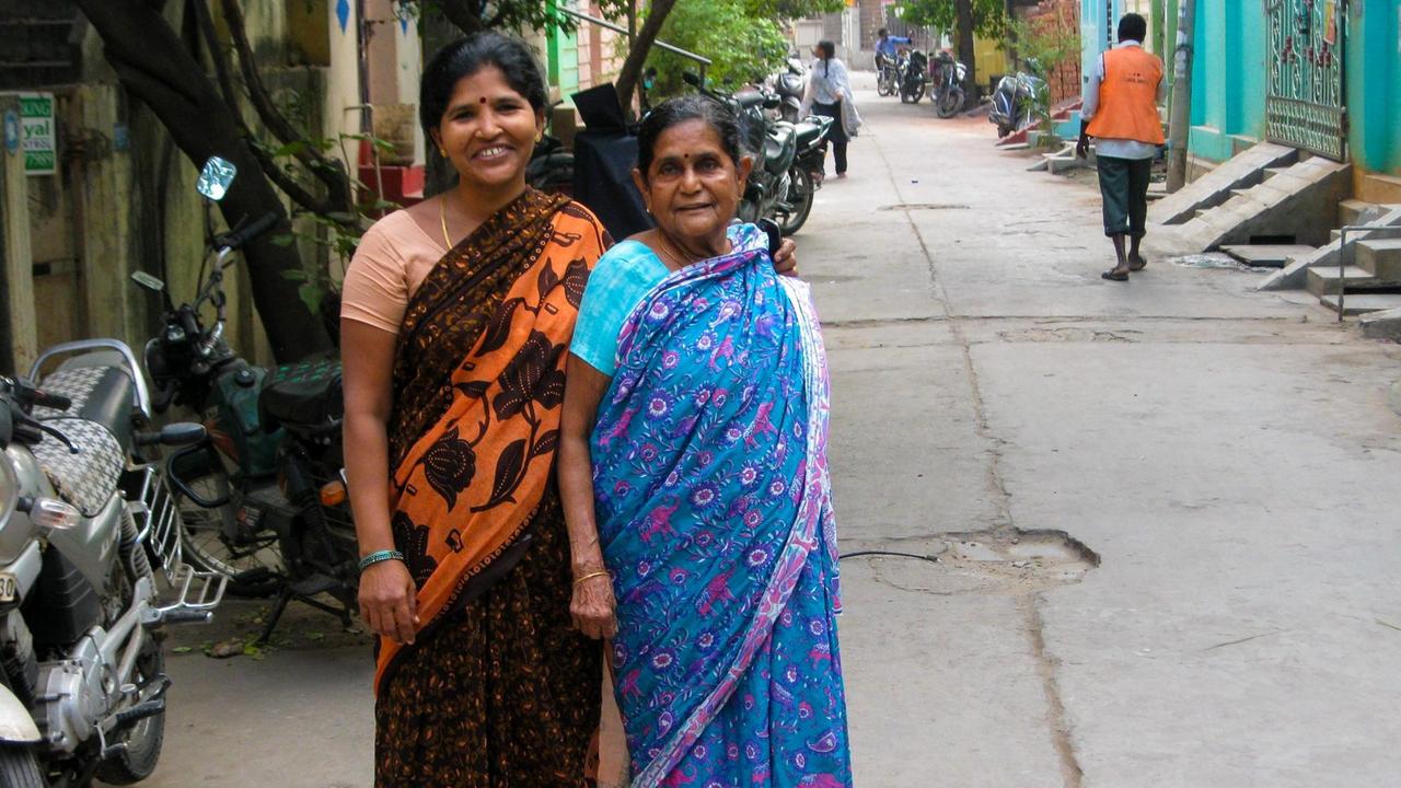 In indischen Wohnvierteln - wie hier in einer Kleinstadt im Süden Indiens -  dominieren tagsüber Frauen das Straßenbild. Zwei Frauen in einer Straße in Südindien.