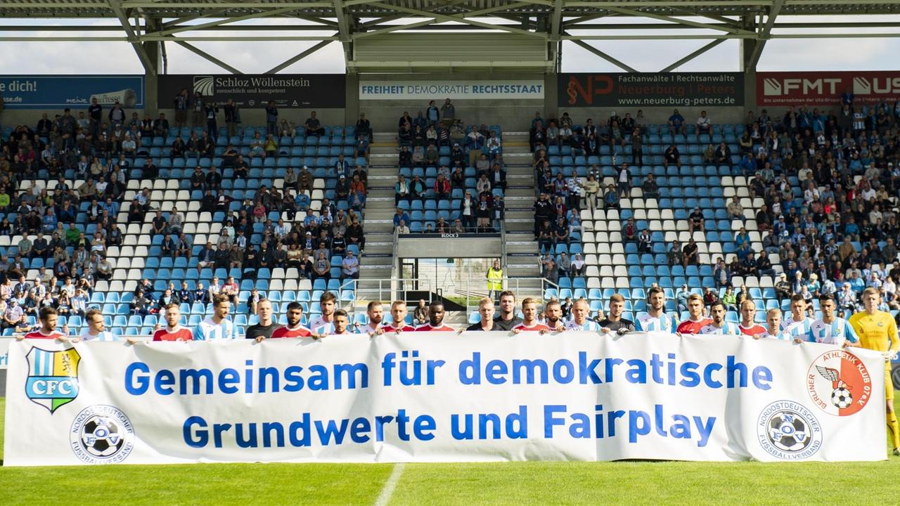 Spieler des Chemnitzer FC und des Berliner AK halten vor Beginn des Spiels ein Banner mit der Aufschrift "Gemeinsam für demokratische Grundwerte und Fairplay". Spieler des Chemnitzer FC und des Berliner AK halten vor Beginn des Spiels ein Banner mit der Aufschrift "Gemeinsam für demokratische Grundwerte und Fairplay".