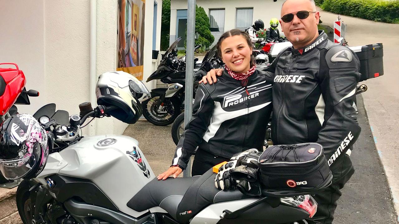 Der Schweizer Motorradfahrer Francisco mit seiner Begleiterin stehen hinter ihrem Motorrad. Der Schweizer Motorradfahrer Francisco mit seiner Begleiterin stehen hinter ihrem Motorrad.