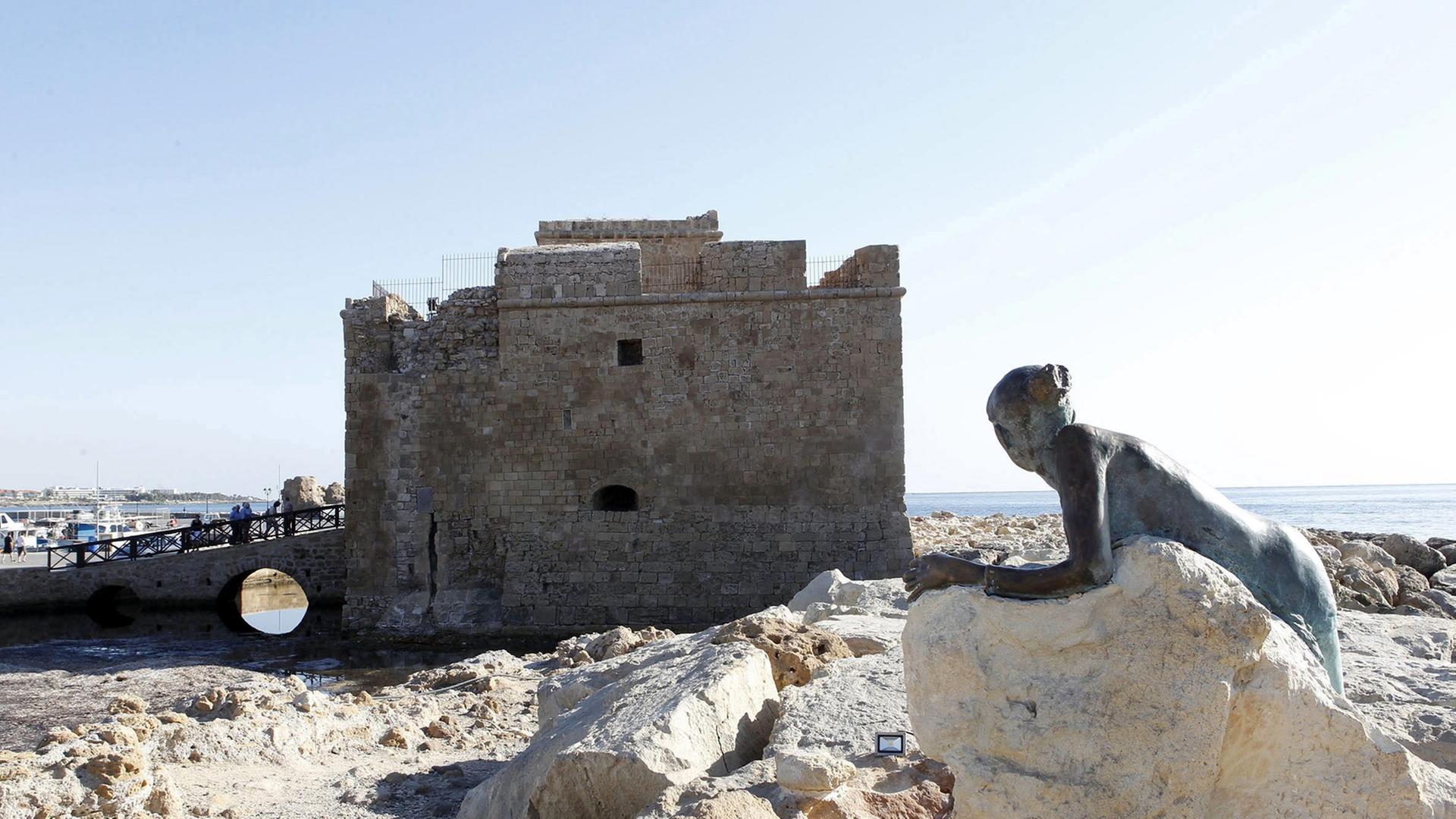 Blick auf die Burg von Paphos und die Aphrodite-Statue des lokalen Künstlers Yiota Ioannidou Blick auf die Burg von Paphos und die Aphrodite-Statue des lokalen Künstlers Yiota Ioannidou