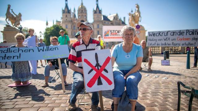 Demonstranten des Aktionsbündnisses "Freier Horizont" legen mit einer Sitzblockade den Verkehr vor dem Landtagssitz in Schwerin lahm.