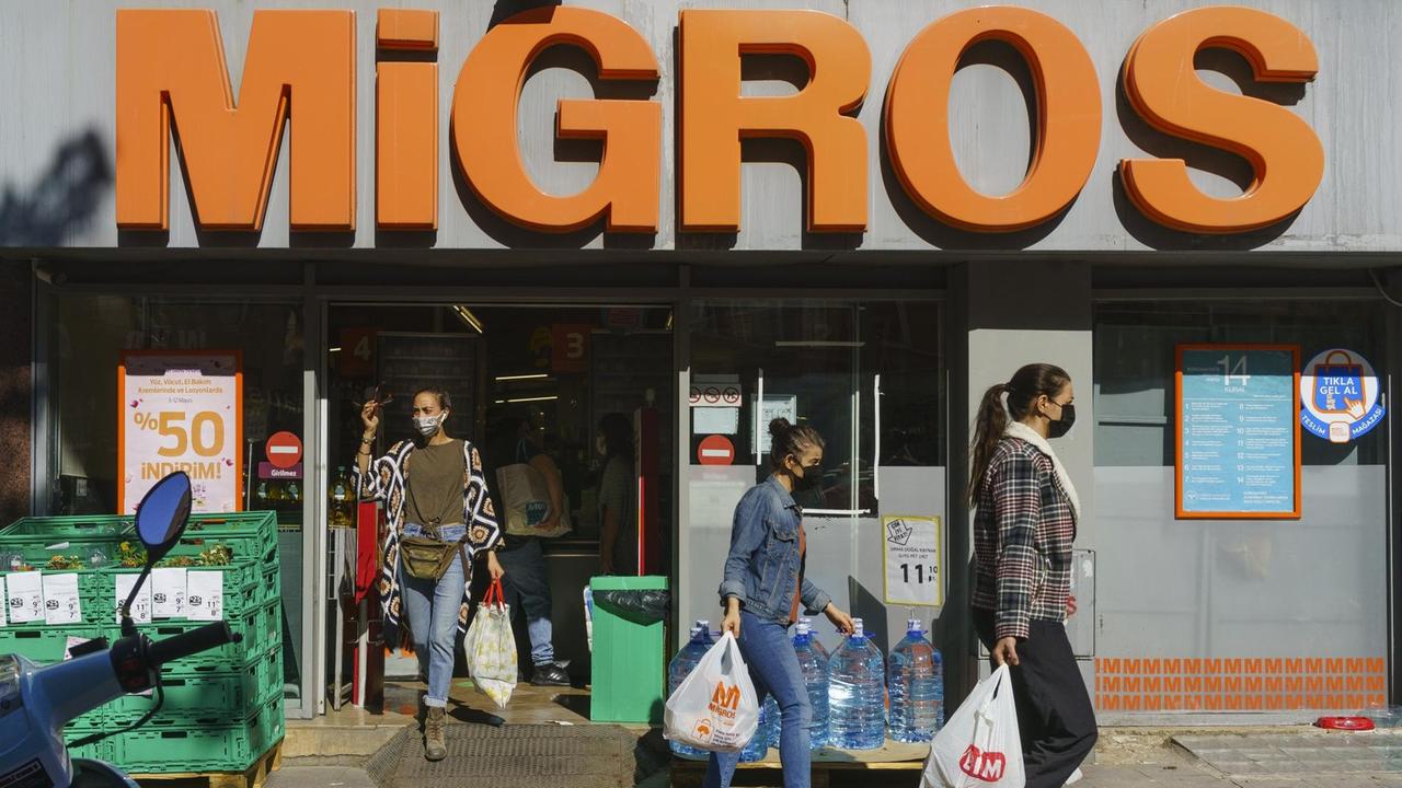 Drei Frauen mit vollen Tüten kommen aus dem Supermarkt Migros in Istanbul. Drei Frauen mit vollen Tüten kommen aus dem Supermarkt Migros in Istanbul.