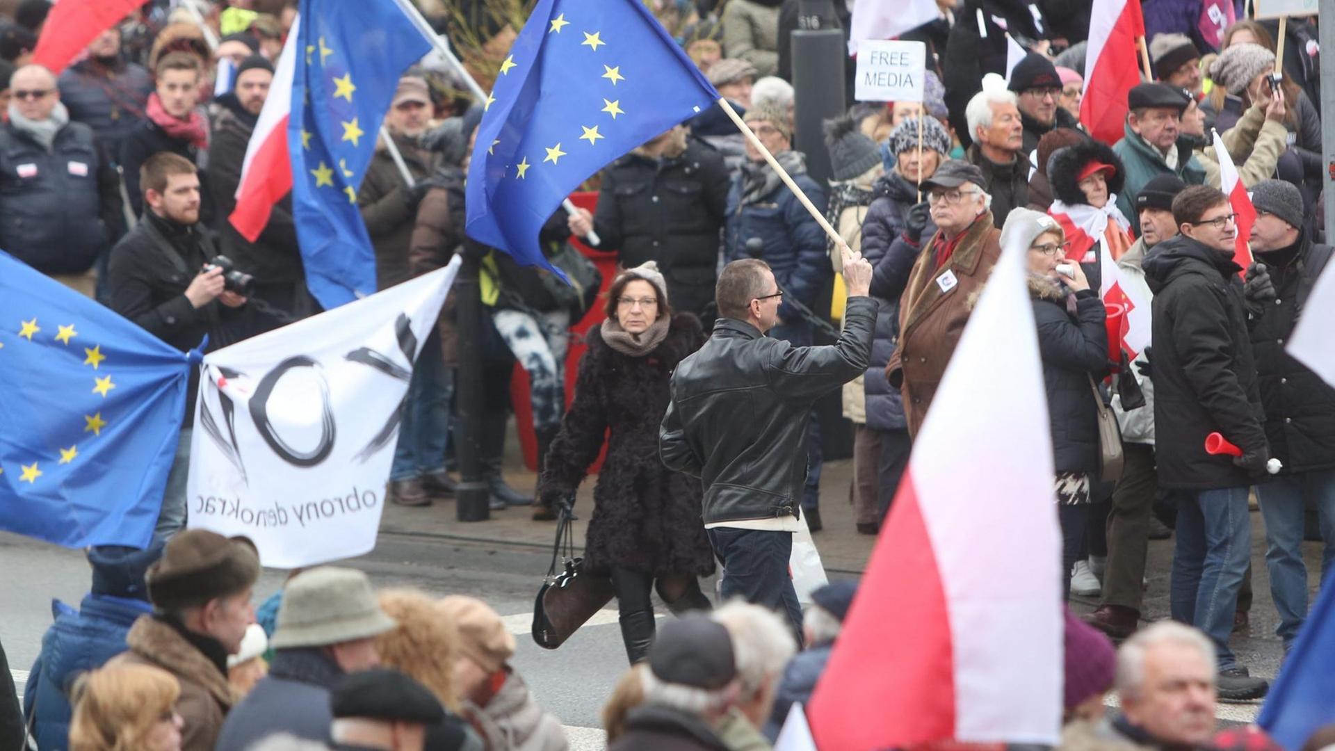 Demonstranten in Warschau mit europäischen und polnischen Fahnen Demonstranten in Warschau mit europäischen und polnischen Fahnen