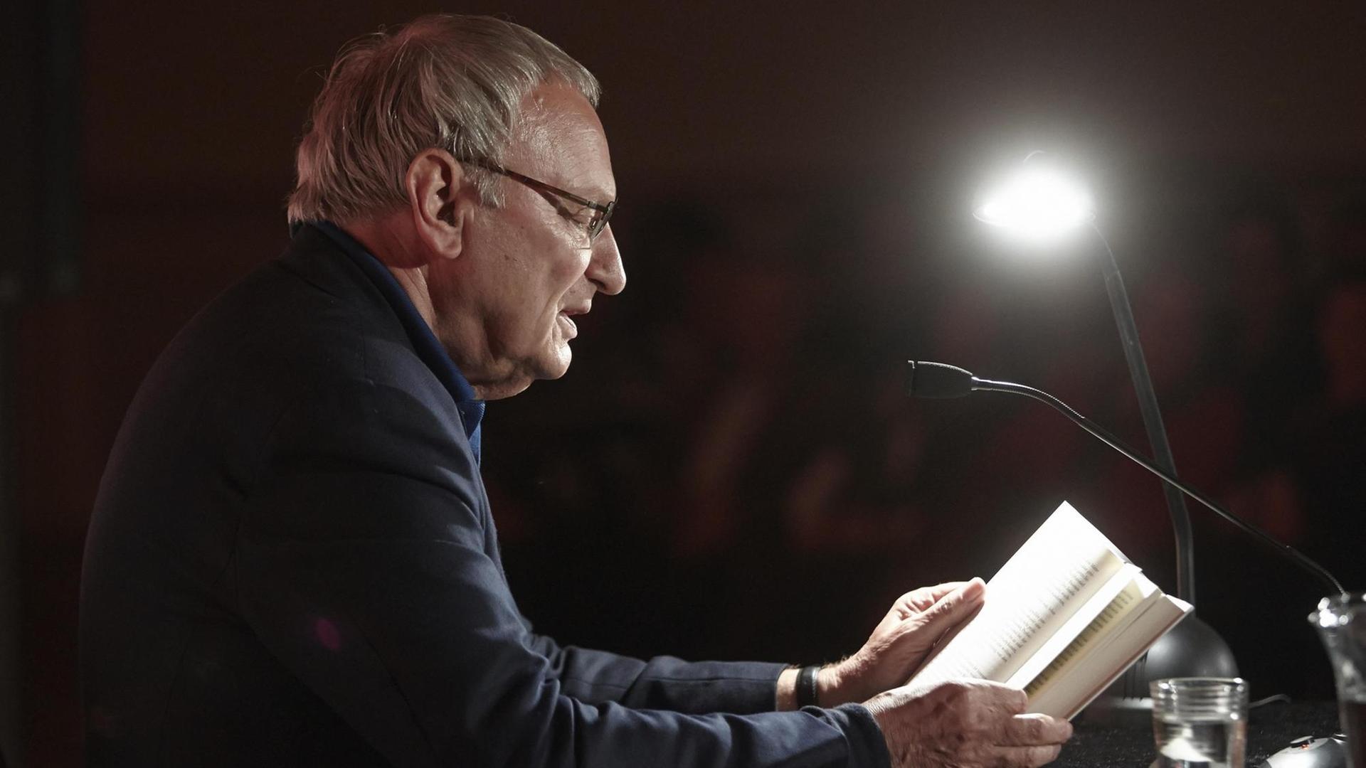 Uwe Timm liest beim Literaturfestival "Ganz Ohr" vor einem Mikrofon. Uwe Timm liest beim Literaturfestival "Ganz Ohr" vor einem Mikrofon.