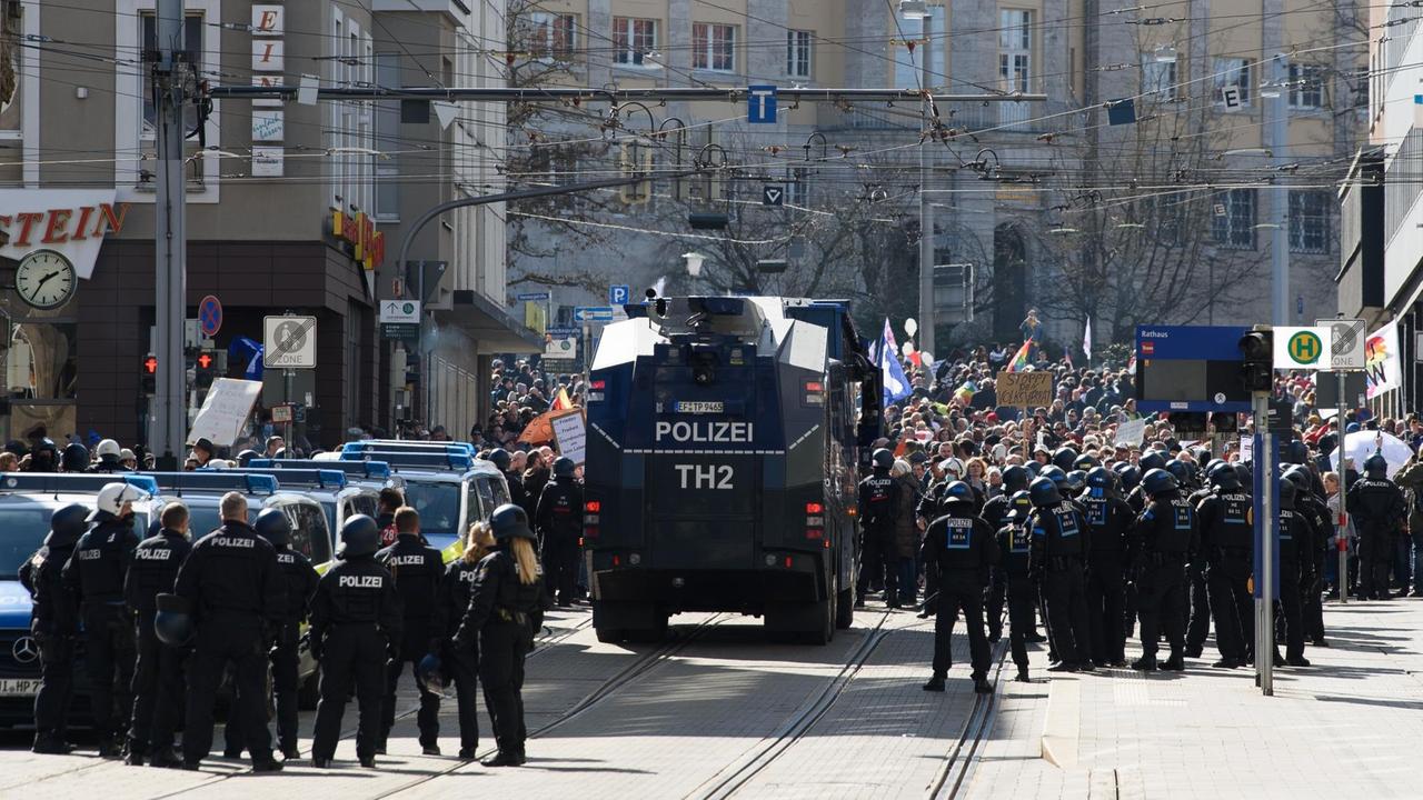 Einsatzkräfte der Polizei stehen bei einer Kundgebung unter dem Motto "Freie Bürger Kassel - Grundrechte und Demokratie" neben einem Wasserwerfer. Einsatzkräfte der Polizei stehen bei einer Kundgebung unter dem Motto "Freie Bürger Kassel - Grundrechte und Demokratie" neben einem Wasserwerfer.