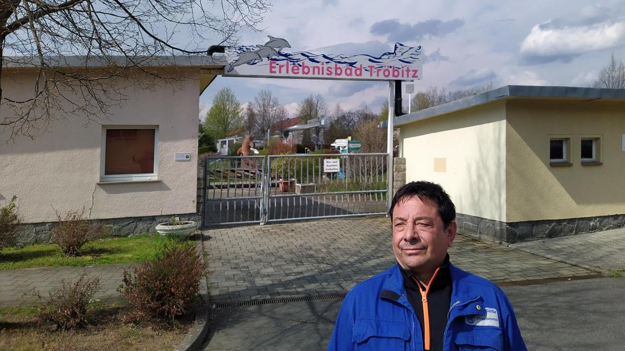 Ein Mann steht im Blaumann vor dem Schwimmbad in Tröbitz. Ein Mann steht im Blaumann vor dem Schwimmbad in Tröbitz.