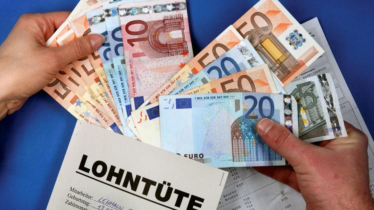 Das Bild aus dem Jahr 2006 zeigt einen Mann, der den Inhalt seiner Lohntüte prüft. Das Bild aus dem Jahr 2006 zeigt einen Mann, der den Inhalt seiner Lohntüte prüft.