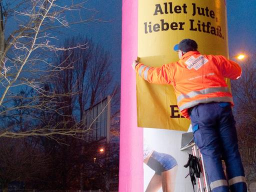 Eine Litfaß-Säule in Berlin wird neu beklebt