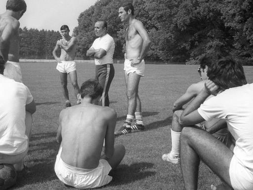 Trainer und Spieler auf einer Wiese
