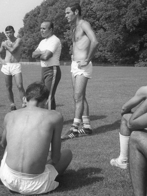 Trainer und Spieler auf einer Wiese