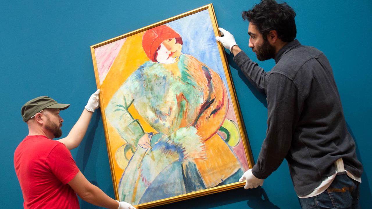Helfer der Schirn Kunsthalle in Frankfurt am Main hängen am 23.10.2015 das Gemälde "Frau mit Pelz und rotem Hut" von Sigrid Hjertén auf. Helfer der Schirn Kunsthalle in Frankfurt am Main hängen am 23.10.2015 das Gemälde "Frau mit Pelz und rotem Hut" von Sigrid Hjertén auf.