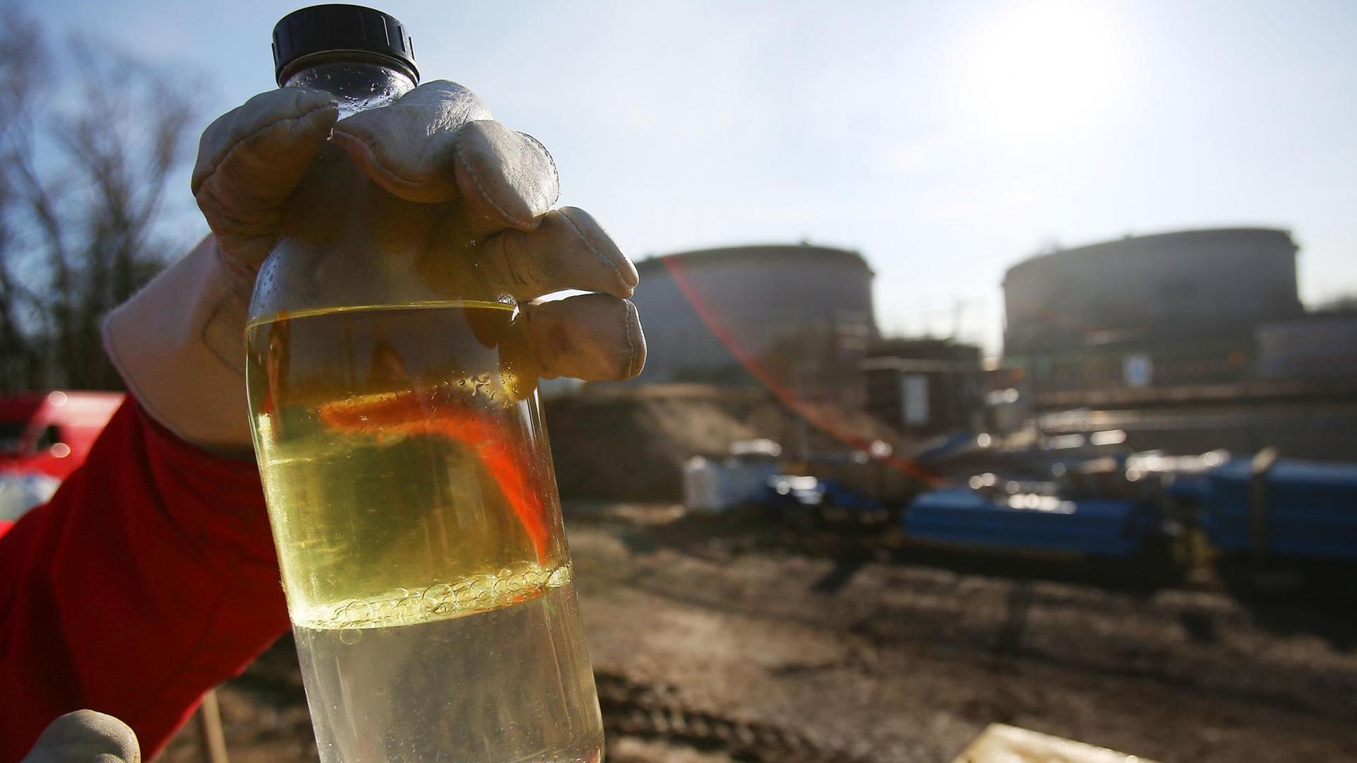 Ein Shell-Mitarbeiter hält am 18.02.2013 in der Nähe der Raffinerie in Wesseling bei Köln (Nordrhein-Westfalen) eine Flasche mit Kerosin und Wasser in der Hand.