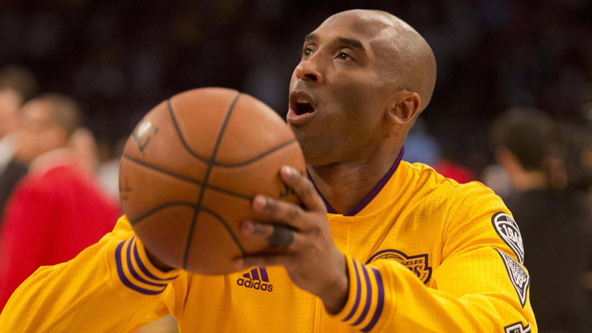 Der Basket-Baller Kobe Bryant wirft einen Ball.