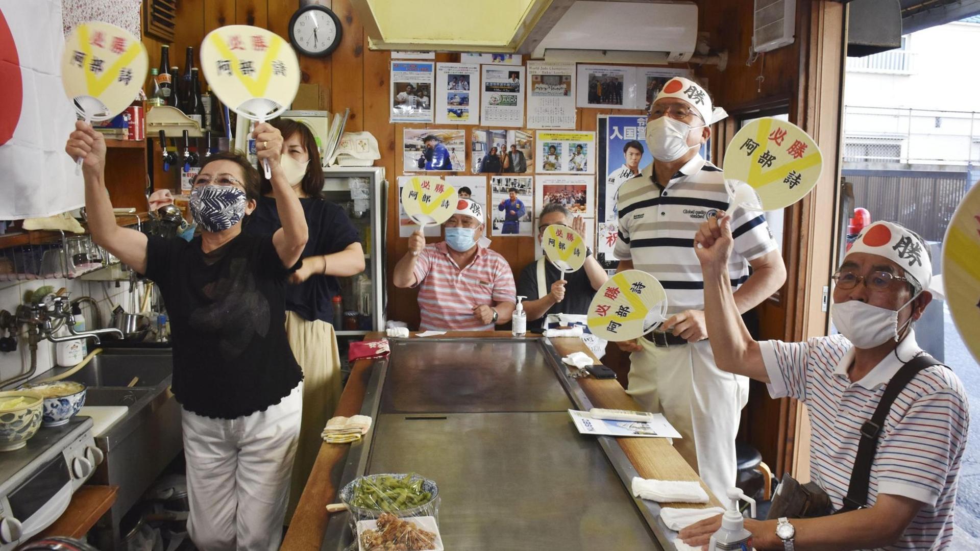 Japanische Olympia-Fans schauen die Wettkämpfe in einem Restaurant in Kobe. Japanische Olympia-Fans schauen die Wettkämpfe in einem Restaurant in Kobe.