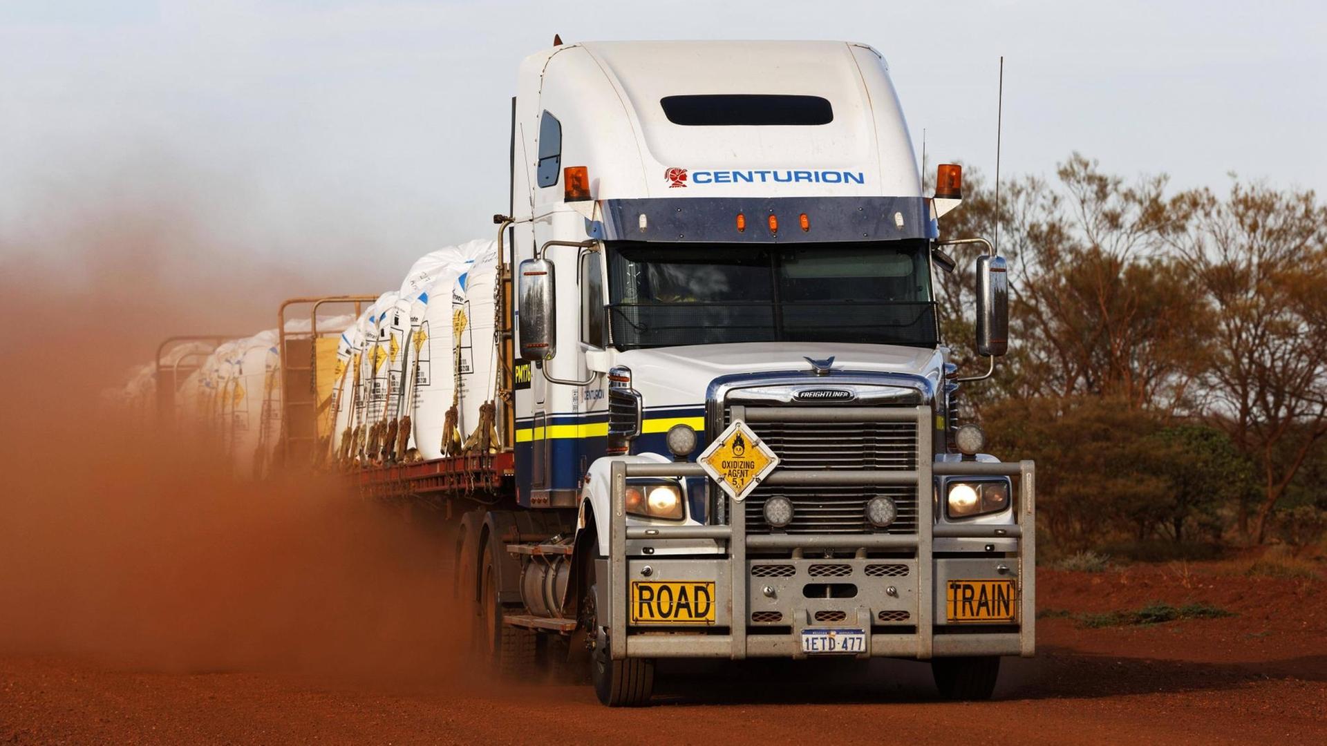 Ein Truck fährt über eine staubige Straße in Australien. Ein Truck fährt über eine staubige Straße in Australien.