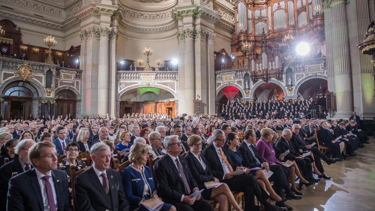 Die Ehrengäste, darunter Bundeskanzlerin Angela Merkel (CDU) sitzen bei den Feierlichkeiten zum Tag der Deutschen Einheit zu Beginn eines ökumenischen Gottesdienstes im Berliner Dom.