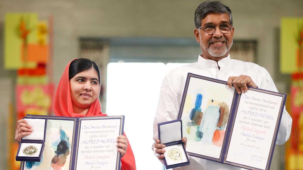Malala Yousafzai (links) und Kailash Satyarthi zeigen ihre Nobelpreisurkunden und -Medaillen während der Preiszeremonie. Malala Yousafzai (links) und Kailash Satyarthi zeigen ihre Nobelpreisurkunden und -Medaillen während der Preiszeremonie.