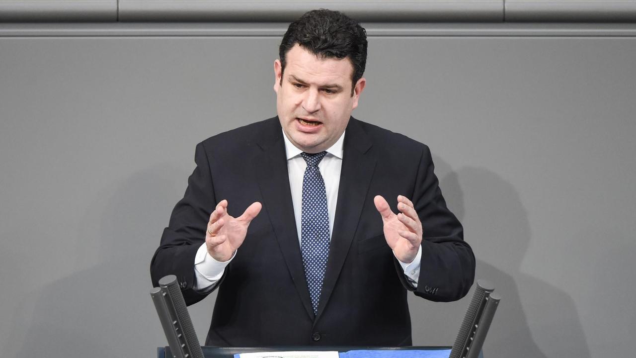 Mann mit schwarzen Haaren in Anzug und Krawatte spricht gestikulierend an einem Rednerpult des Deutschen Bundestages Mann mit schwarzen Haaren in Anzug und Krawatte spricht gestikulierend an einem Rednerpult des Deutschen Bundestages