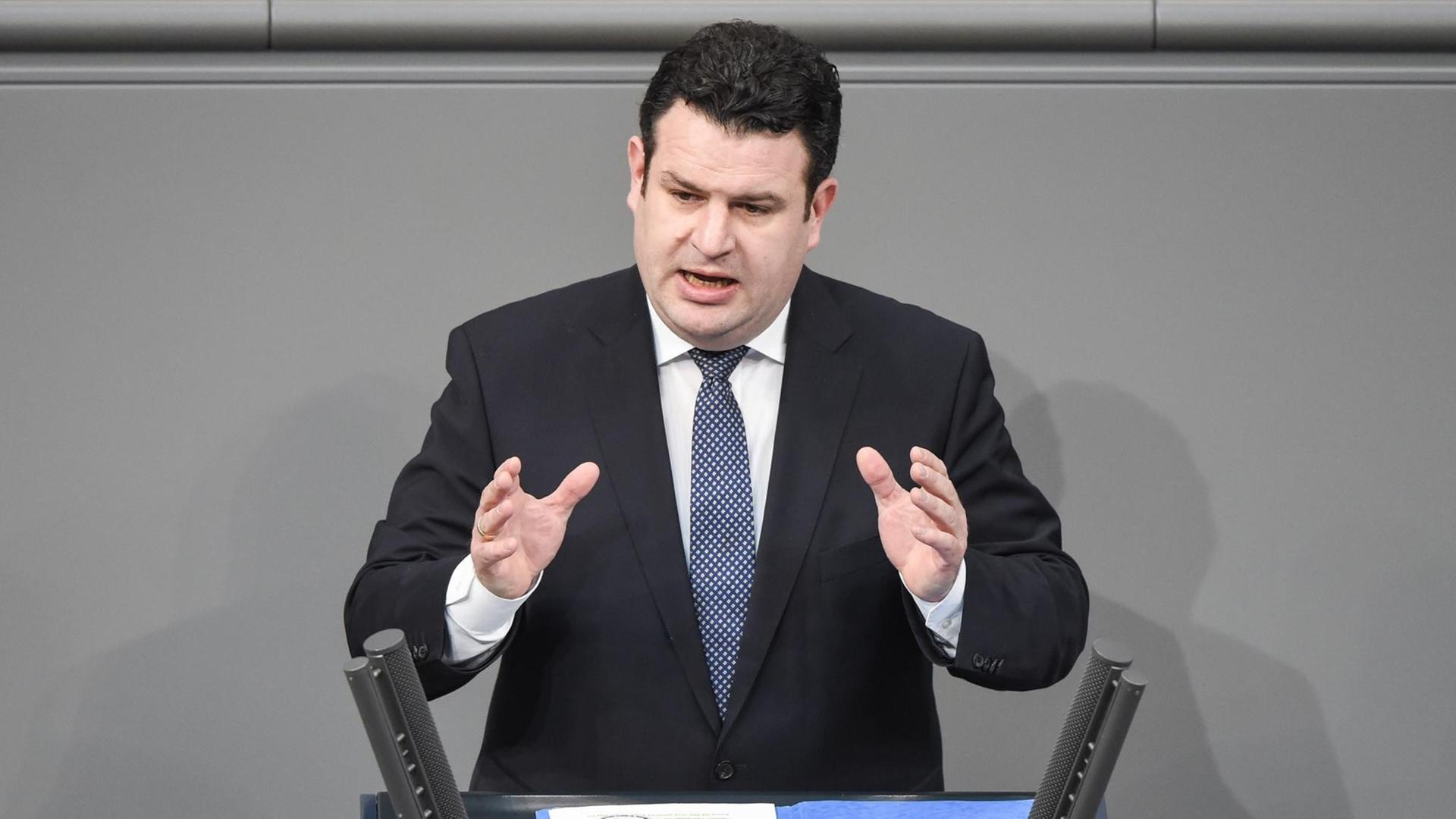 Bundesarbeitsminister Heil spricht in Anzug und Krawatte gestikulierend an einem Rednerpult des Deutschen Bundestages. Bundesarbeitsminister Heil spricht in Anzug und Krawatte gestikulierend an einem Rednerpult des Deutschen Bundestages.