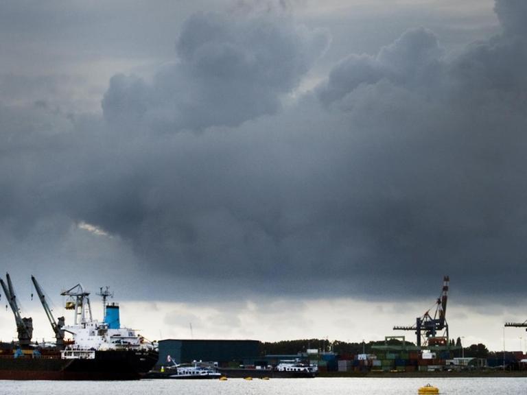 Rotterdamer Hafen mit Wolken am Horizont.