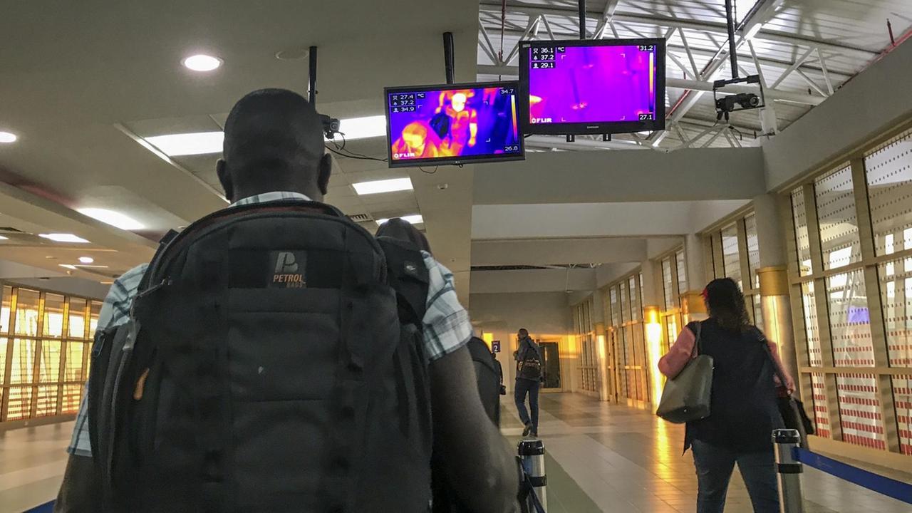 Passengers from an Ethiopian Airlines flight from Addis Ababa walk past a thermal imaging camera checking for signs of fever as a screening mechanism against signs of infection with the Novel Coronavirus or Ebola, upon their arrival at the Jomo Kenyatta International Airport in Nairobi, Kenya Thursday, Feb. 6, 2020. (AP Photo/Ben Curtis) |